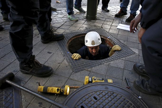 Policemen check a drain outside the Santiago Bernabeu stadium before the 'Clasico' soccer match between Real Madrid and Barcelona in Madrid, Spain, November 21, 2015. REU