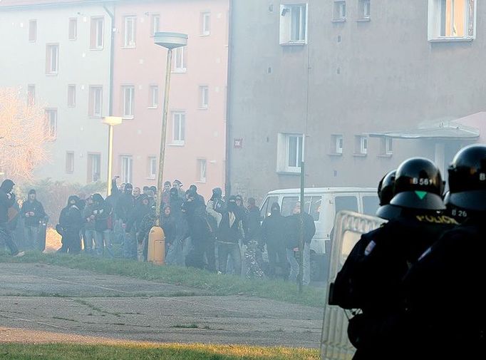 Těsně před janovským sídlištěm se extremisté v několika skupinách rozeběhli před duněním policejních dělobuchů mezi nejbližší domy. Na policisty přitom házeli vše, co bylo po ruce - tedy kameny, klacky a lahve.