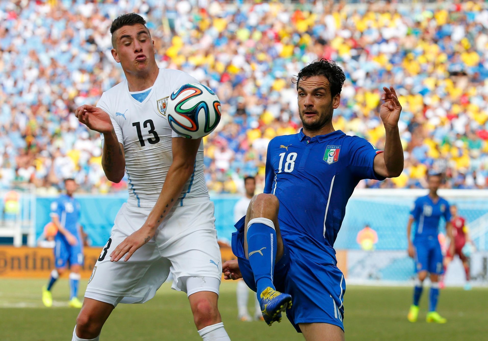 Uruguay's Jose Maria Gimenez fights for the ball with Italy's Marco Parolo during their 2014 World Cup Group D soccer match at the Dunas arena