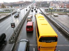 Žlutý autobus vjíždí na Nuselský most a do Prahy. Student Agency denně vypraví 80 autobusů jedním nebo druhým směrem po D1.