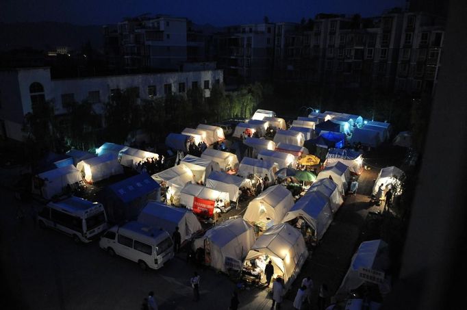 Tents outside a hospital light up at night after Saturday's earthquake hit Lushan county, Ya'an, Sichuan province, April 22, 2013. Hundreds of survivors of an earthquake that killed nearly 200 people in southwest China pushed into traffic on a main road on Monday, waving protest signs, demanding help and shouting at police. The Chinese characters on the tent read "Disaster relief". Picture taken April 22, 2013. REUTERS/Stringer (CHINA - Tags: DISASTER SOCIETY TPX IMAGES OF THE DAY) Published: Dub. 23, 2013, 3:17 dop.