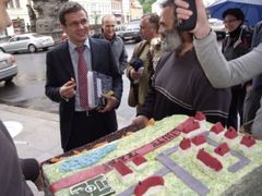 Ministr Ondřej Liška ochutnává před výjezdním zasedáním v Teplicích dort, který symbolizuje limity těžby chránící Horní Jiřetín
