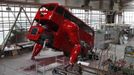 Workers are seen at a factory hall in Prague as artist David Cerny (not pictured) works on his project to transform a London bus into a robotic sculpture June 25, 2012. The bus, which Cerny hopes could become an unofficial mascot of the London 2012 Olympic Games, does push-ups with the help of an engine powering a pair of robotic arms and the motion is accompanied by a recording of sounds evoking tough physical effort. It will be parked outside the Czech Olympic headquarters in London for the duration of the Games. Picture taken June 25, 2012. REUTERS/David W Cerny (CZECH REPUBLIC - Tags: SOCIETY SPORT OLYMPICS TRANSPORT) Published: Čec. 22, 2012, 5:55 odp.