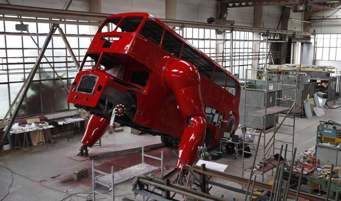 Workers are seen at a factory hall in Prague as artist David Cerny (not pictured) works on his project to transform a London bus into a robotic sculpture June 25, 2012. The bus, which Cerny hopes could become an unofficial mascot of the London 2012 Olympic Games, does push-ups with the help of an engine powering a pair of robotic arms and the motion is accompanied by a recording of sounds evoking tough physical effort. It will be parked outside the Czech Olympic headquarters in London for the duration of the Games. Picture taken June 25, 2012. REUTERS/David W Cerny (CZECH REPUBLIC - Tags: SOCIETY SPORT OLYMPICS TRANSPORT) Published: Čec. 22, 2012, 5:55 odp.