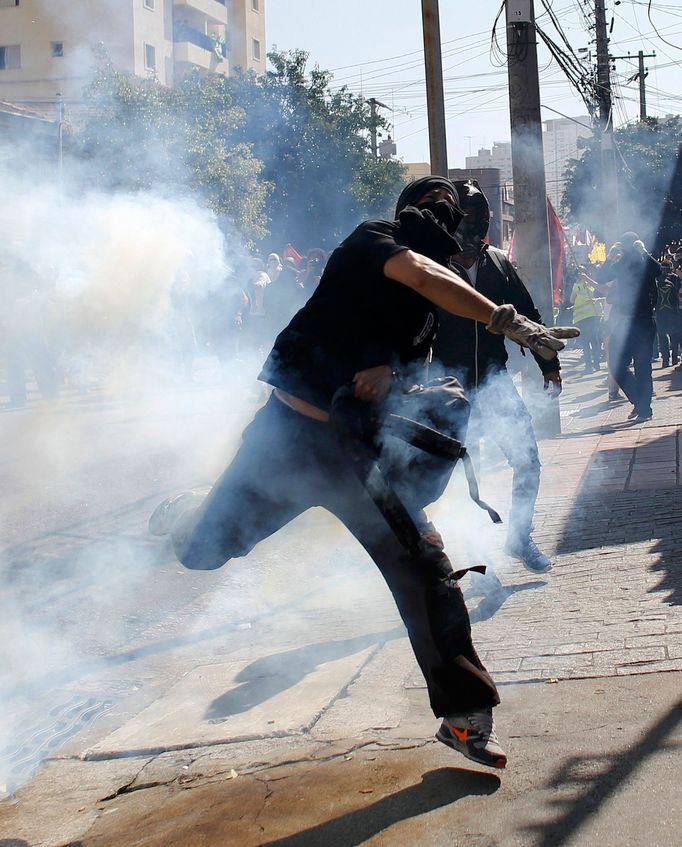 A demonstrator throws a tear gas bomb after military police shot at demonstrators during a protest against the 2014 World Cup, in Sao Paulo June 12, 2014. REUTERS/Nacho D