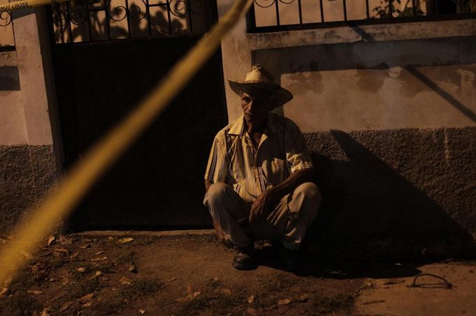 A resident looks at a crime scene in the city of San Pedro Sula March 22, 2013. Unknown assailants killed three men and one woman on Friday at the crime scene in a working class neighbourhood, local media reported. San Pedro Sula has been labelled the most violent city on the planet, according to a U.N. Development Program report last week. Picture taken March 22, 2013. REUTERS/Jorge Cabrera (HONDURAS - Tags: CIVIL UNREST CRIME LAW) Published: Bře. 23, 2013, 9:10 odp.