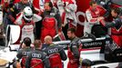 Driver of Audi R18 E-Tron Quattro Allan McNish (L) of Britain adjusts his helmet as driver number 2 Tom Kristensen (R) of Denmark speaks with a mechanic, just before the