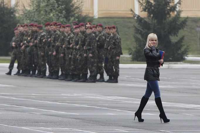 A woman visitor passes a platoon of freshly drafted recruits at the parade square of an infantry unit camp based in Kiev October 15, 2012. REUTERS/Gleb Garanich (UKRAINE - Tags: MILITARY TPX IMAGES OF THE DAY SOCIETY) Published: Říj. 15, 2012, 12:23 odp.