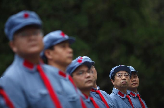 Mid-level government officials dressed in red army uniforms listen to a lesson as they visit an old house where former Chinese leader Mao Zedong used to live, during a five-day training course at the communist party school called China Executive Leadership Academy of Jinggangshan, in Jiangxi province September 21, 2012. China Executive Leadership Academy was established in 2005 by the Central Committee of the Communist Party of China, after the 16th Communist Party Congress in 2002. By the end of August 2012, the academy has held 789 training classes for almost 40,000 people. During the course, trainees listen and sing revolutionary songs, visit old revolutionary sites and review historical communist materials. China has yet to announce the starting date for the 18th Communist Party Congress, China's biggest political meeting in a decade, which will see the transfer of power from President Hu Jintao and Premier Wen Jiabao to a new generation. REUTERS/Carlos Barria (CHINA - Tags: POLITICS SOCIETY) Published: Zář. 21, 2012, 3:25 odp.