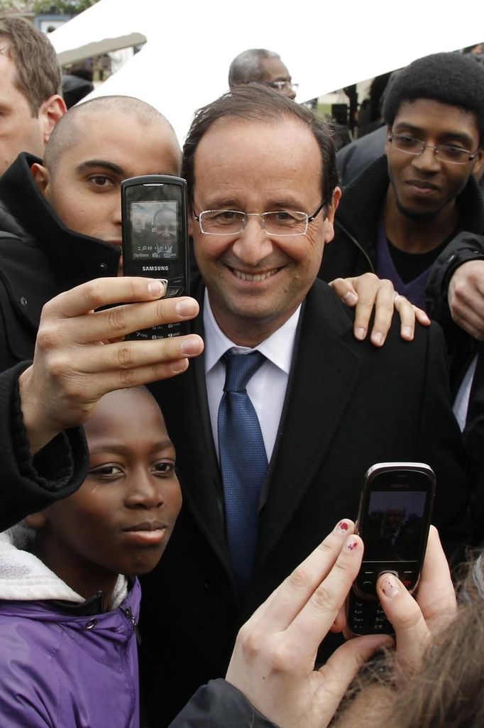 French presidential election candidate Hollande takes pictures with supporters in Aubervilliers