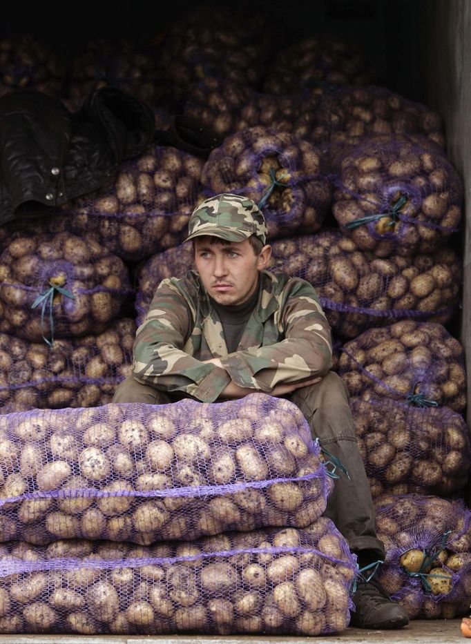 A man selling potatoes waits for customers during an autumn fair at a street market in Minsk October 13, 2012. REUTERS/Vasily Fedosenko (BELARUS - Tags: AGRICULTURE SOCIETY BUSINESS FOOD) Published: Říj. 13, 2012, 11:07 dop.