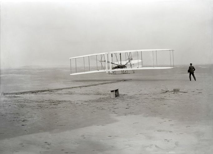 První motorizovaný let v dějinách. Stroj řídí Orville Wright. 17. prosince 1903.