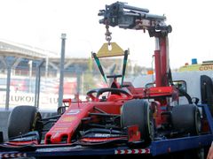 Porouchané Ferrari Sebastiana Vettela v boxech v Soči.