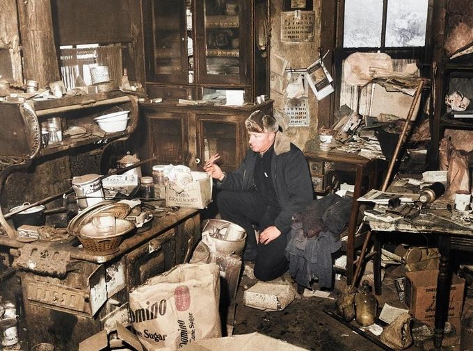 Policista zkoumá nepořádek v kuchyni domu Eda Geina u Plainfieldu ve Wisconsinu, 20. listopadu 1957. Kolorováno