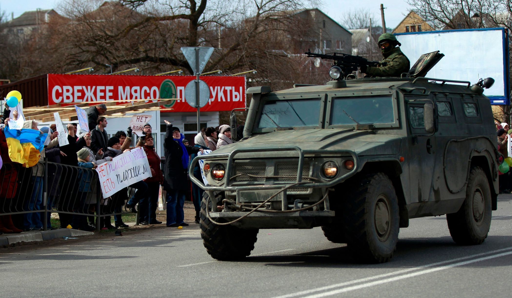 Proukrajinští demonstranti reagují na vojenské vozidlo, pravděpodobně ruské, u města Simferopol