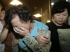 Matka a rodina uneseného devětadvacetiletého Šim Sung-mina pláče poté, co viděli televizní zpravodajství.