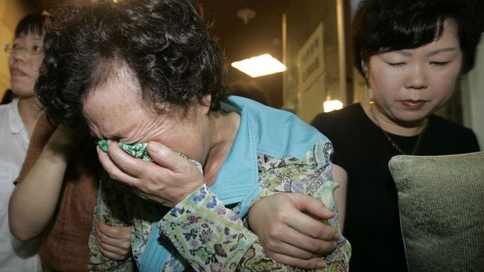 Matka s rodinou uneseného devětadvacetiletého Šim Sung-mina pláčí poté, co viděly televizní zpravodajství....