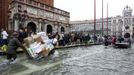 A worker transports materials in St. Mark Square during a period of seasonal high water in Venice October 27, 2012. The water level in the canal city rose to 127 cm (50 inches) above the normal level, according to the monitoring institute. REUTERS/Manuel Silvestri (ITALY - Tags: ENVIRONMENT SOCIETY TRAVEL) Published: Říj. 27, 2012, 12:25 odp.