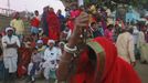 People watch a devotee, believed to be possessed by evil spirits, dance while holding an iron chain in a state of trance at Guru Deoji Maharaj temple during a ghost fair at Malajpur village in Betul district in the central Indian state of Madhya Pradesh January 27, 2013. People from across India come to this fair to be exorcised of �evil spirits�. They are usually brought by relatives and they are most often women. The exorcism involves running around the temple courtyard to make the 'ghost' weak then being beaten by a priest with a broom. Picture taken January 27, 2013. REUTERS/Danish Siddiqui (INDIA - Tags: SOCIETY RELIGION TPX IMAGES OF THE DAY) ATTENTION EDITORS: PICTURE 7 OF 24 FOR PACKAGE 'INDIAN GHOSTBUSTERS' SEARCH 'INDIA GHOST' FOR ALL IMAGES Published: Úno. 5, 2013, 5:09 dop.