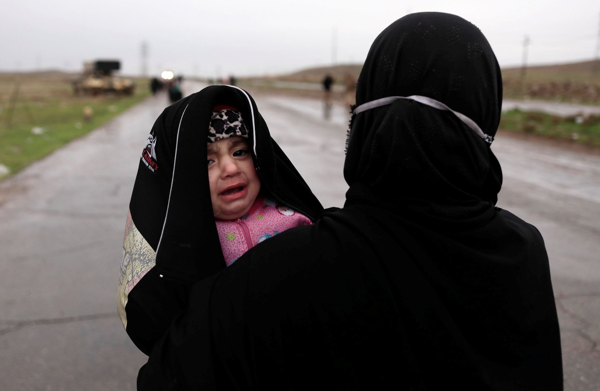 Žena s dítětem prchá z Mosulu.
