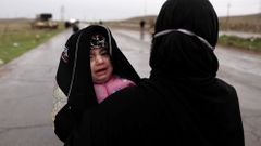 Žena s dítětem prchá z Mosulu.