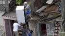 A resident (top) salvages a refrigerator from his damaged house, with the help of other men, after Hurricane Sandy hit Santiago de Cuba October 25, 2012. Strengthening rapidly after tearing into Jamaica and crossing the warm Caribbean Sea, Sandy hit southeastern Cuba early on Thursday with 105-mph winds that cut power and blew over trees across the city of Santiago de Cuba. Reports from the city of 500,000 people, about 470 miles (750 km) southeast of Havana spoke of significant damage, with many homes damaged or destroyed. REUTERS/Miguel Rubiera/Cuban Government National Information Agency-AIN/Handout (CUBA - Tags: DISASTER ENVIRONMENT TPX IMAGES OF THE DAY) FOR EDITORIAL USE ONLY. NOT FOR SALE FOR MARKETING OR ADVERTISING CAMPAIGNS. THIS IMAGE HAS BEEN SUPPLIED BY A THIRD PARTY. IT IS DISTRIBUTED, EXACTLY AS RECEIVED BY REUTERS, AS A SERVICE TO CLIENTS Published: Říj. 25, 2012, 9:59 odp.