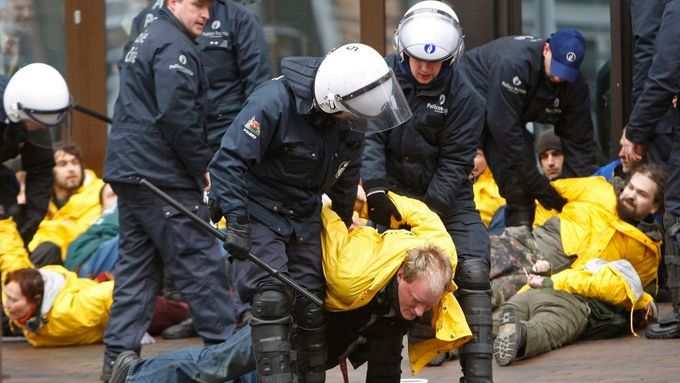Policie se snaží odtáhnout aktivisty z Greenpeace od vchodu do budovy, kde se radí ministři financí EU