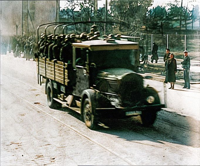 Německé vojenské vozidlo s vojáky projíždí ulicí Varšavy, Polsko, 1939, během začátku německé okupace. Kolorovaný snímek