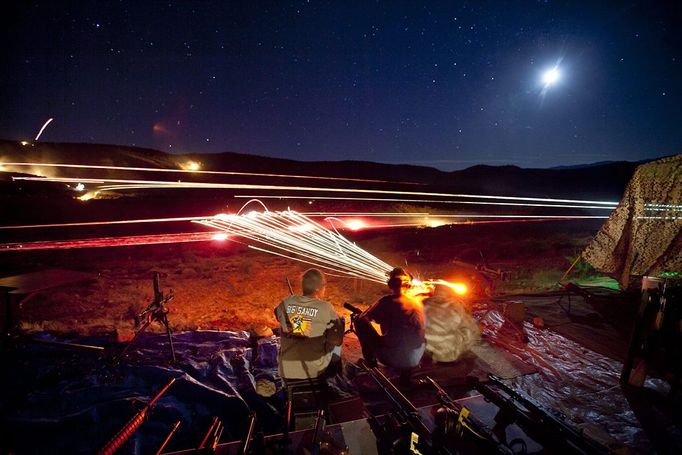 Gun Enthusiasts Gather for Machine Gun Shoot in Rural Arizona 2012-10-19 00:00:00 epa03515002 (21/22) A long exposure image shows visitors to the Big Sandy Machine Gun Shoot firing their machine guns as flares, tracer fire, and the moon light up the night sky outside Wikieup, Arizona, USA, 19 October 2012. Twice a year, the Big Sandy lures gun enthusiasts to the Sonoran Desert for a weekend of firing heavy weaponry. EPA/JIM LO SCALZO