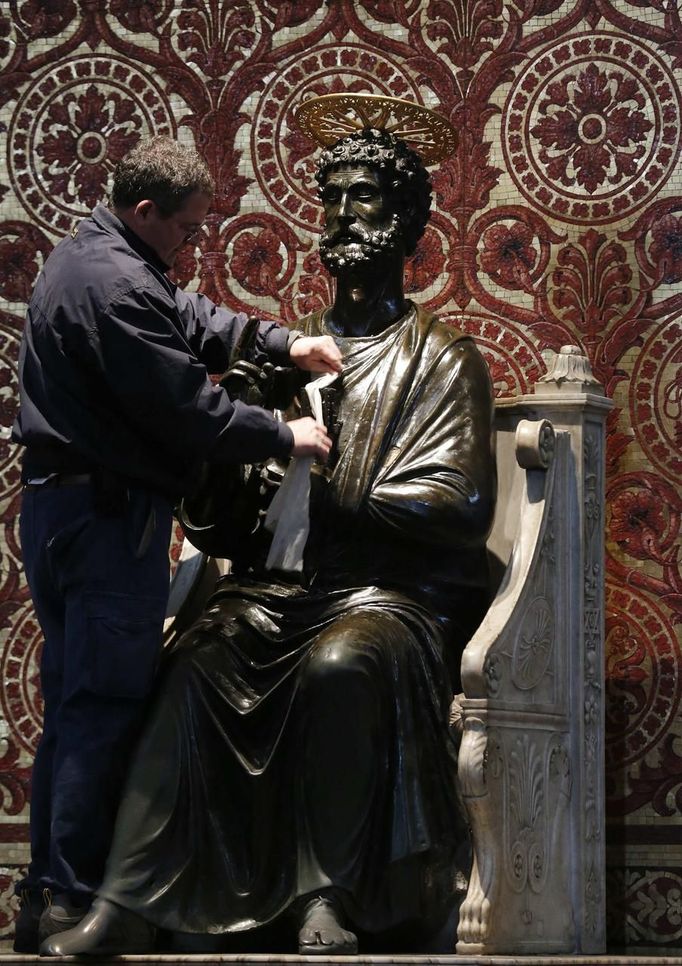 A worker cleans the Statue of Saint Peter inside the Basilica at the Vatican March 11, 2013. Roman Catholic Cardinals will begin their conclave inside the Vatican's Sistine Chapel on Tuesday to elect a new pope. REUTERS/Christian Hartmann (VATICAN - Tags: RELIGION) Published: Bře. 11, 2013, 10:51 dop.