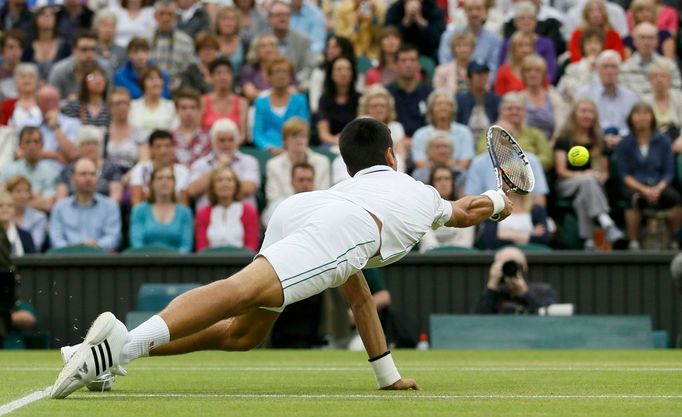 Srbský tenista Novak Djokovič se natahuje po míčku v semifinálovém utkání Wimbledonu 2012 se Švýcarem Rogerem Federerem.