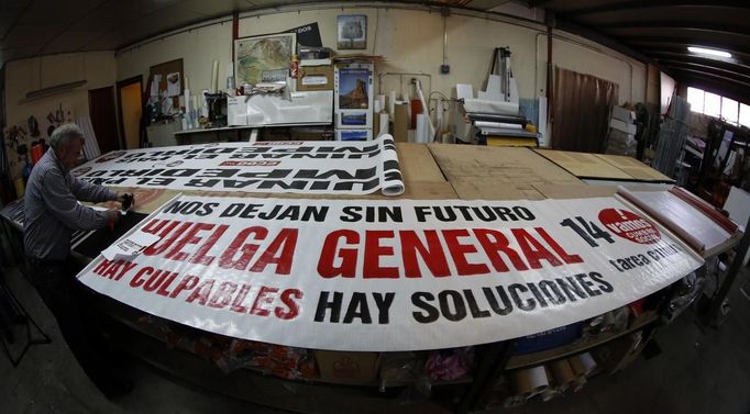 Esteban Carrasco works next to a banner calling for a general strike in Pinto, near Madrid, November 12, 2012. Spain's two largest labour unions had called a general strike for November 14, the second against the conservative government since they took power in December and coinciding with industrial action in Portugal on the same day. The banner reads, "They leave us without future. General Strike. There are culprits, there are solutions." REUTERS/Sergio Perez (SPAIN - Tags: BUSINESS EMPLOYMENT POLITICS CIVIL UNREST) Published: Lis. 12, 2012, 2:02 odp.