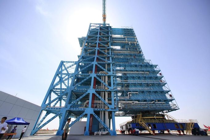 A soldier stands guard in front of the launch pad holding the Long March II-F rocket loaded with the Shenzhou-9 manned spacecraft, in Jiuquan Satellite Launch Center, Gansu province, June 16, 2012. China will send its first woman into outer space this week, prompting a surge of national pride as the rising power takes its latest step towards putting a space station in orbit within the decade. Liu Yang, a 33-year-old fighter pilot, will join two other astronauts aboard the Shenzhou 9 spacecraft when it lifts off from a remote Gobi Desert launch site on Saturday evening. REUTERS/Jason Lee (CHINA - Tags: MILITARY SCIENCE TECHNOLOGY) Published: Čer. 16, 2012, 5:10 dop.