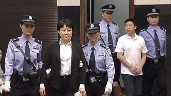 Ku Kchaj-laj (druhá zleva) je eskortována do soudní síně.