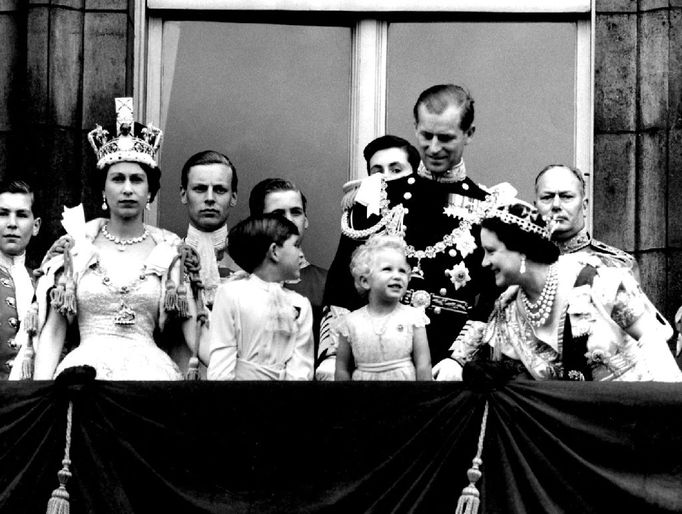 With a charmingly grandmotherly smile, Queen Elizabeth, The Queen Mother, stoops to ask an enchanted Princess Anne whether she is enjoying the RAF fly-past as members of the Royal family stand on the balcony of Buckingham Palace after the Coronation at Westminster Abbey. Prince Charles looks to his father, The Duke of Edinburgh, who smiles down on his daughter, Princess Anne. The Queen, wearing the Imperial state crown, gazes at the crowds milling around the gates of the Palace. Background, left to right, The Duke of Gloucester, uncle of the Queen. 2nd June 1953