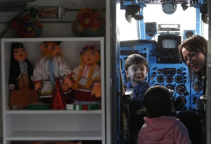 Children play in the cockpit of a plane at a kindergarten in the town of Rustavi some 25 km (15 miles) south of Tbilisi, October 31, 2012. The fully functional Soviet-era Yakovlev Yak-40 plane has been installed in the kindergarten courtyard and refurbished as a children's playground. REUTERS/David Mdzinarishvili (GEORGIA - Tags: EDUCATION SOCIETY) Published: Říj. 31, 2012, 11:17 dop.