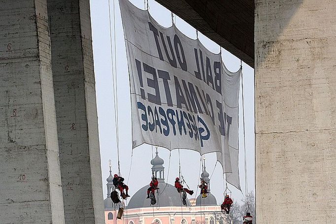 Horolezci z řad hnutí Greenpeace na Nuselském mostě nerušeně připevnili transparent. "Vykupte klima!"