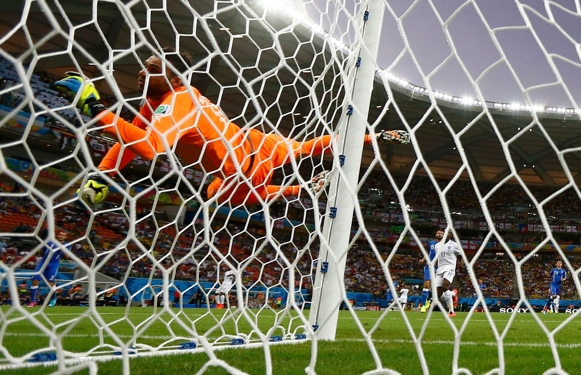 Italy's Sirigu dives as he watches a shot by England's Sterling hit the side netting during their 2014 World Cup Group D soccer match at the Amazonia arena in Manaus