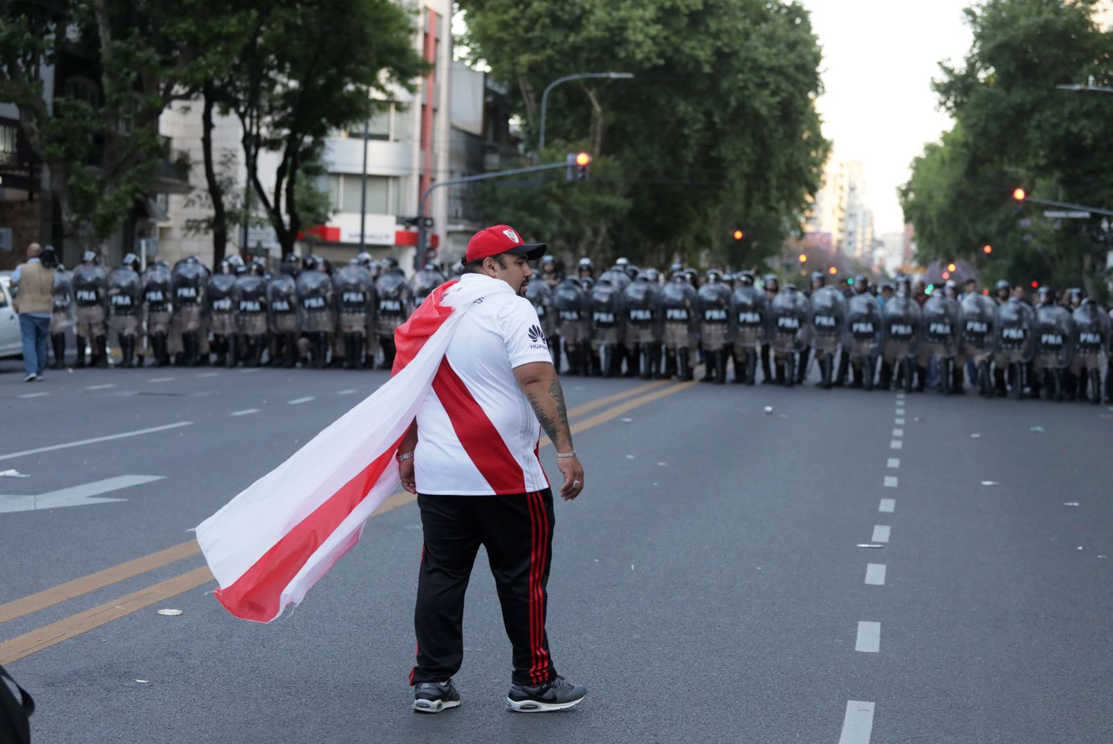 fotbal. Pohár osvoboditelů 2018, Boca Juniors - River Plate, fanoušek River Plate před kordonem policistů