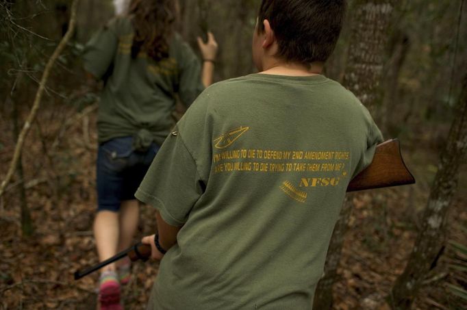 A young boy with the North Florida Survival Group follows his group while performing a land navigation drill during a field training exercise in Old Town, Florida, December 8, 2012. The group trains children and adults alike to handle weapons and survive in the wild. The group passionately supports the right of U.S. citizens to bear arms and its website states that it aims to teach "patriots to survive in order to protect and defend our Constitution against all enemy threats". Picture taken December 8, 2013. REUTERS/Brian Blanco (UNITED STATES - Tags: SOCIETY POLITICS) ATTENTION EDITORS: PICTURE 7 OF 20 FOR PACKAGE 'TRAINING CHILD SURVIVALISTS' SEARCH 'FLORIDA SURVIVAL' FOR ALL IMAGES Published: Úno. 22, 2013, 1 odp.