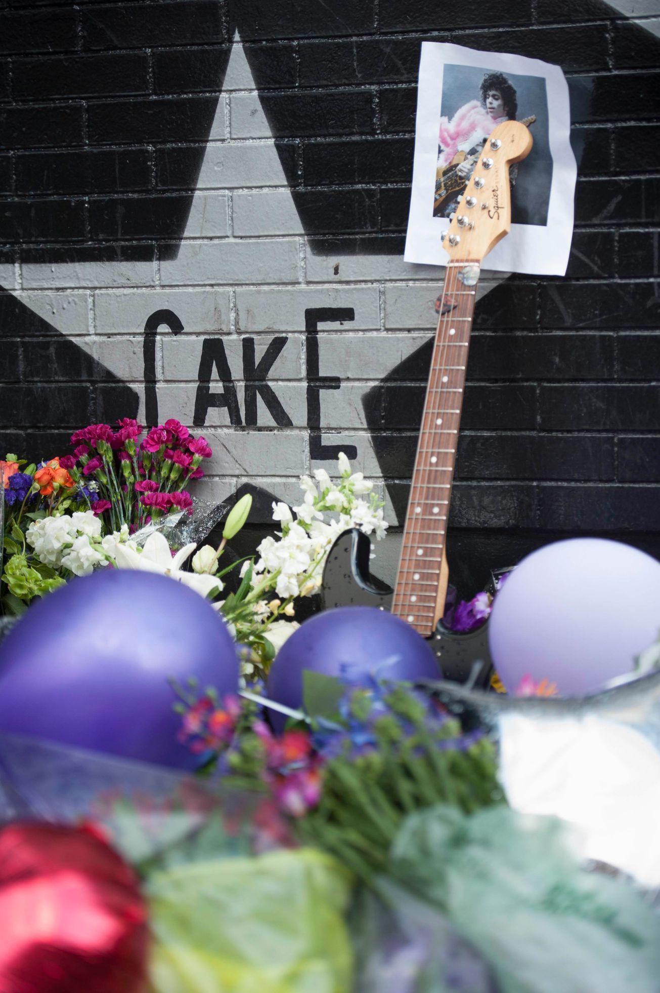 A photo of Prince is held up by a guitar leaning against First Avenue, the nightclub where U.S. music superstar Prince got his start in Minneapolis Minnesota