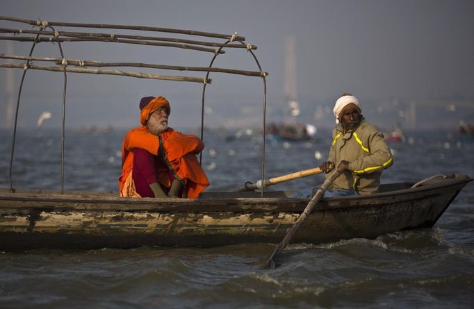 A man ferries a Hindu devotee in his boat over the Ganges river ahead of the "Kumbh Mela" (Pitcher Festival), in the northern Indian city of Allahabad January 11, 2013. During the festival, Hindus take part in a religious gathering on the banks of the river Ganges. "Kumbh Mela" will return to Allahabad in 12 years. REUTERS/Ahmad Masood (INDIA - Tags: RELIGION) Published: Led. 11, 2013, 10:29 dop.