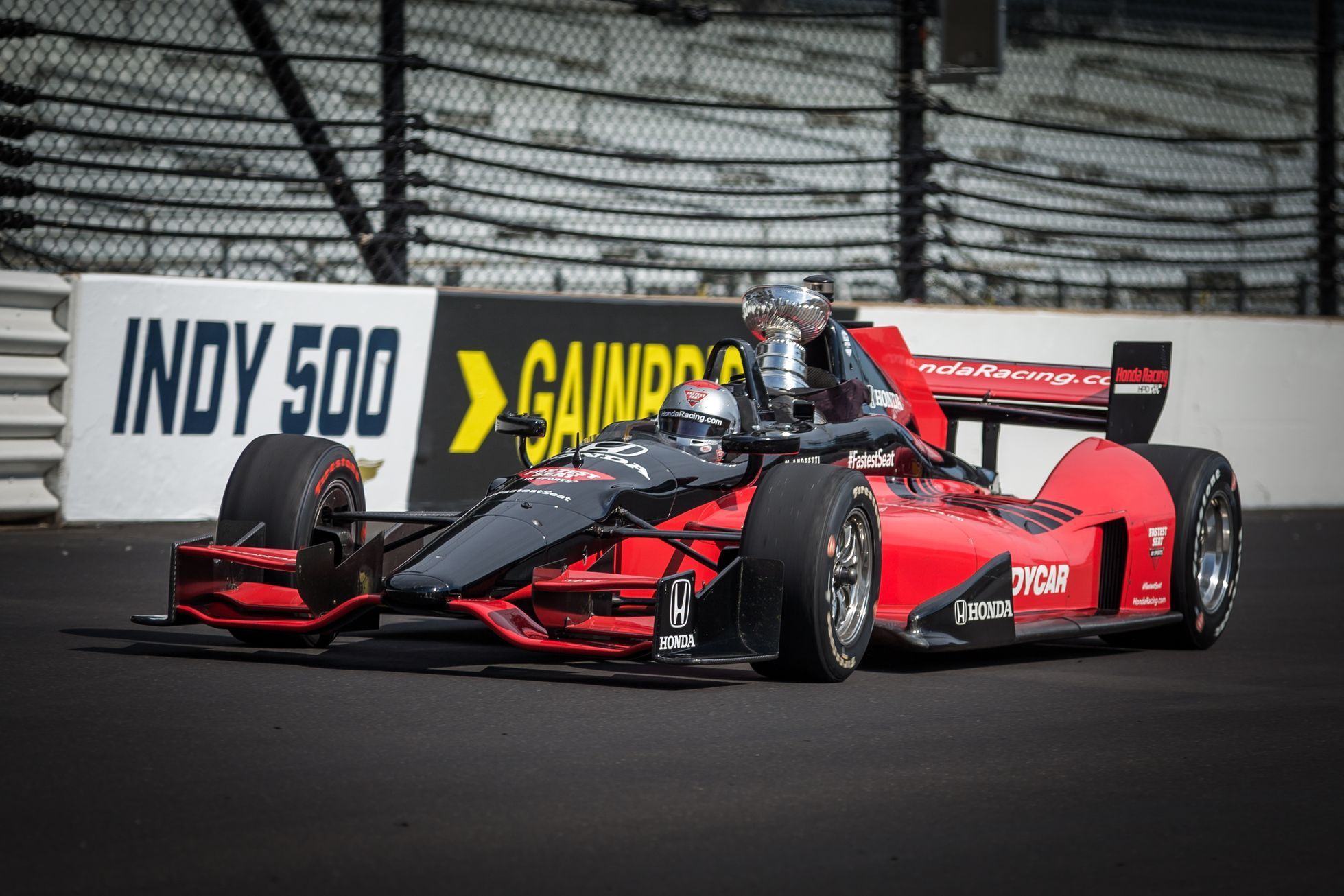 Mario Andretti pilotuje dvojsedadlovou formuli IndyCar, v níž je usazen Stanley Cup