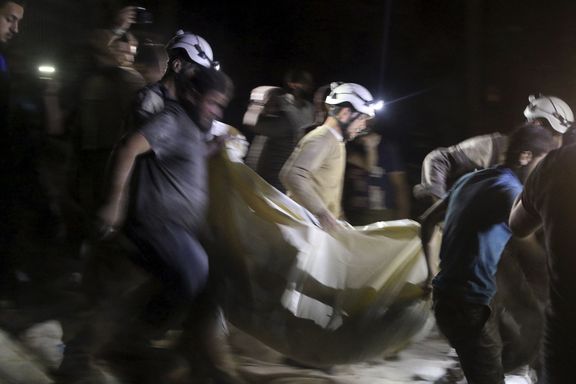 Členové civilní obrany vynášejí z nemocnice těla obětí nočního náletu.