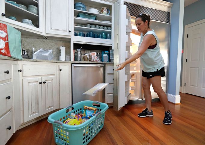 Michelle Stober, of Cary, N.C., removes food from a freezer as she prepares their vacation home in advance of Hurricane Florence in Wrightsville Beach, N.C.