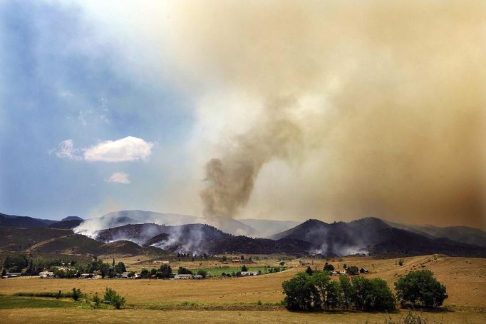 Smoke and flames encroach upon homes and ranches on the eastern front of the High Park fire near Laporte, Colorado June 10, 2012. A wind-driven wildfire burning in a rugged Colorado canyon spread out of control, forcing hundreds of people to evacuate and one person in the fire zone was reported missing, officials said on Sunday. REUTERS/Marc Piscotty (UNITED STATES - Tags: DISASTER ENVIRONMENT) Published: Čer. 10, 2012, 9:38 odp.