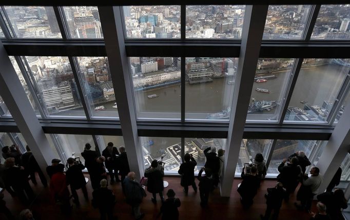 Visitors look out from windows in The View gallery at the Shard in London