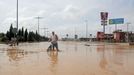 A man wades through a flooded street after heavy rains in San Javier