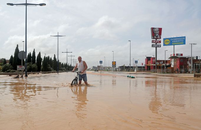 A man wades through a flooded street after heavy rains in San Javier