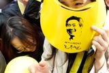 Dívka se před policejním zásahem symbolicky brání čepičkou s podobiznou Ro Mu-hjona.